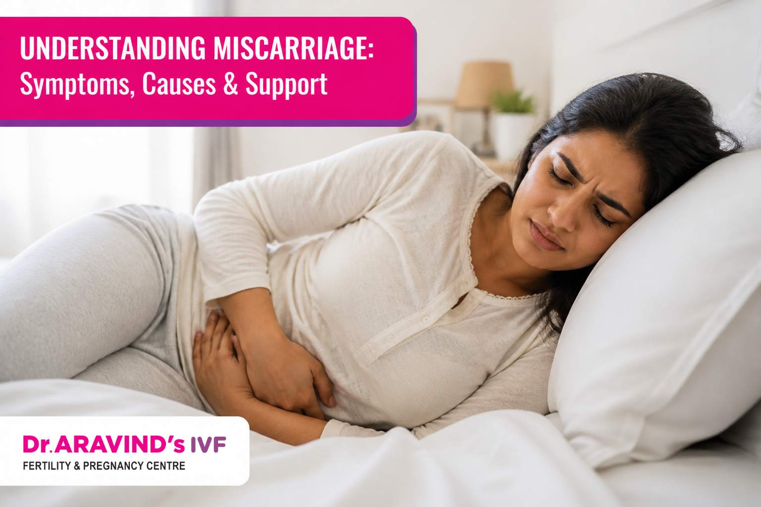 Woman lying on a bed holding her lower abdomen in pain, representing early miscarriage symptoms and causes